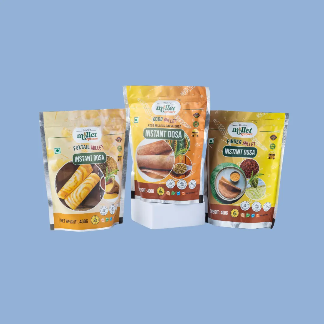 Three packets of instant millet dosa mix featuring Foxtail Millet, Kodo Millet, and Finger Millet varieties displayed against a light blue background.