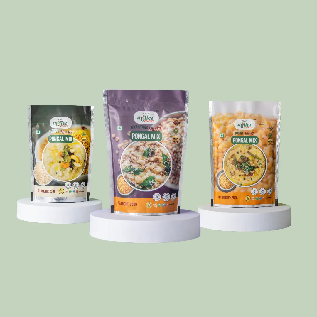 Three packaged millet pongal mix products displayed on white podiums against a soft green background, featuring Little Millet, Barnyard Millet, and Kodo Millet varieties.
